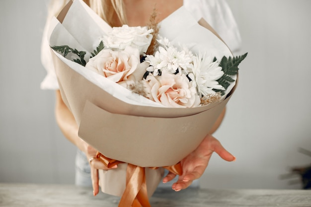 Fleuriste avec des fleurs. La femme fait un bouquet.