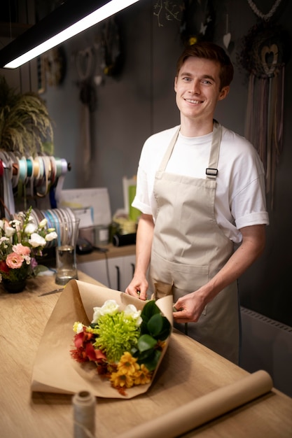 Photo gratuite fleuriste masculin faisant un beau bouquet