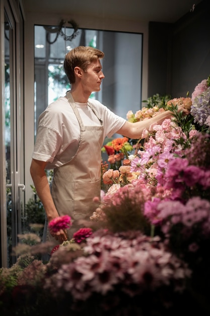 Photo gratuite fleuriste masculin faisant un beau bouquet