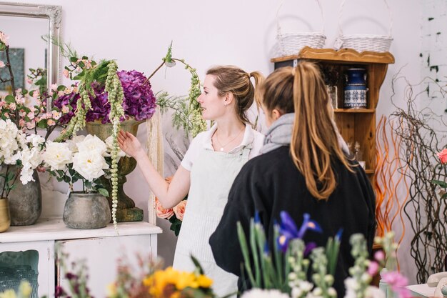 Fleuriste montrant des fleurs au client