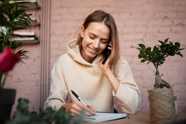 Fleuriste souriant parlant au téléphone coup moyen