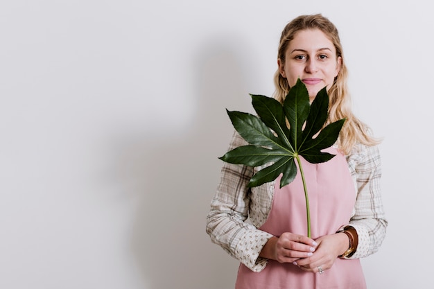 Photo gratuite fleuriste en tablier avec feuille