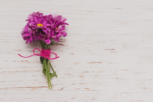 Fleurs attachées sur une surface en bois blanc