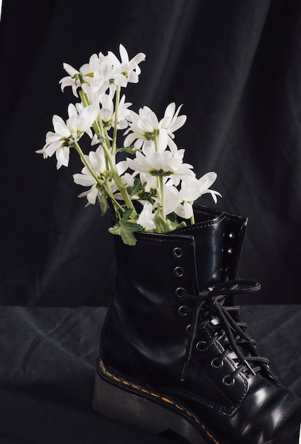 Fleurs blanches en bottes foncées