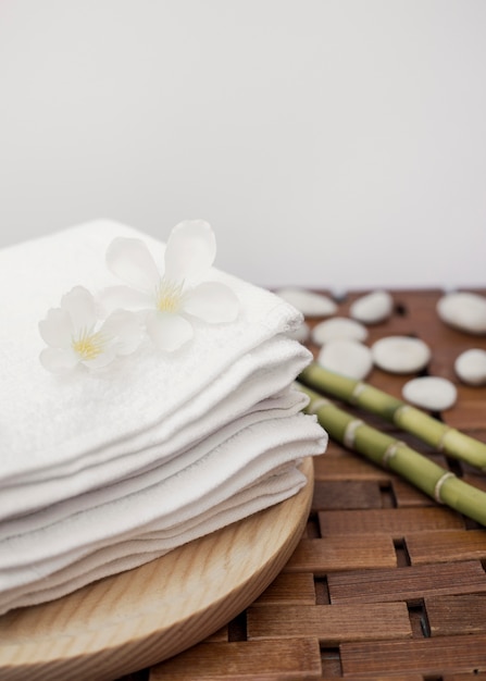 Fleurs blanches et serviettes empilées sur un plateau en bois