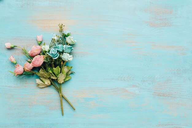 Fleurs bleues et roses avec un fond en bois vintage.