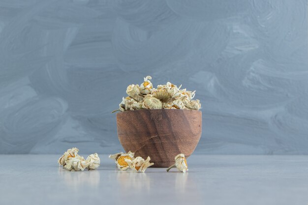 Fleurs de camomille séchées dans un bol en bois.