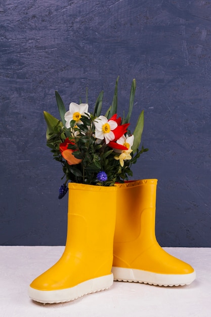 Photo gratuite des fleurs dans des bottes jaunes