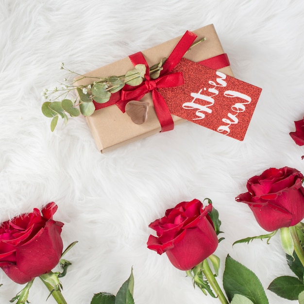 Fleurs fraîches et cadeau avec étiquette sur la couverture en laine