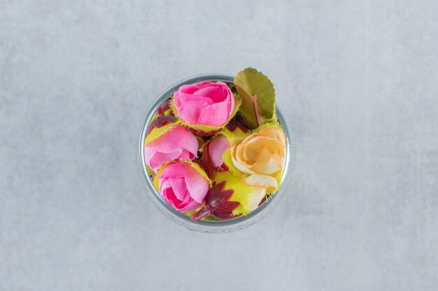 Fleurs fraîches et élégantes dans un verre, sur fond blanc. photo de haute qualité
