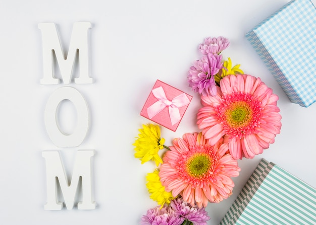 Photo gratuite fleurs fraîches près des boîtes présentes et mot maman