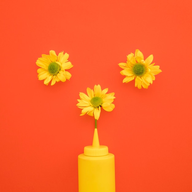 Photo gratuite fleurs jaunes près de la bouteille