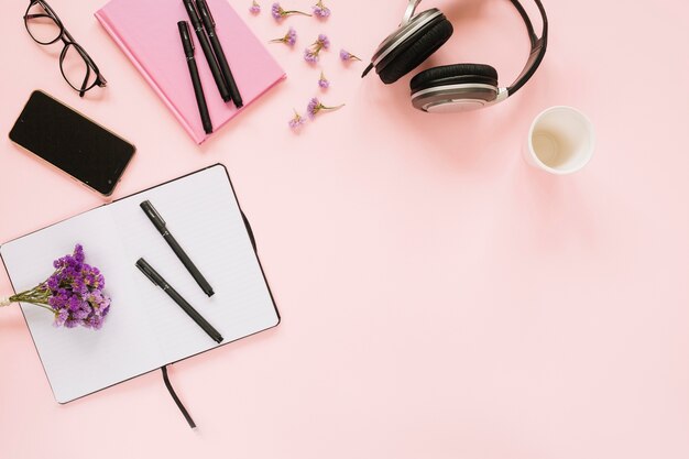 Fleurs de lavande avec papeterie de bureau et téléphone portable sur fond rose