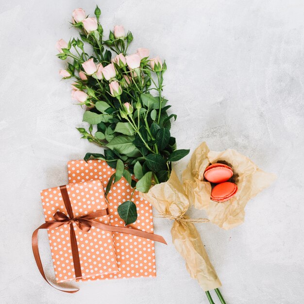 Fleurs et macarons près de cadeaux