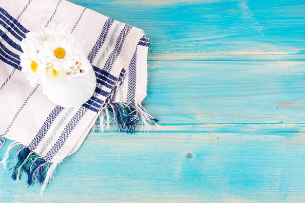 Fleurs de Marguerite en pichet sur table bleue