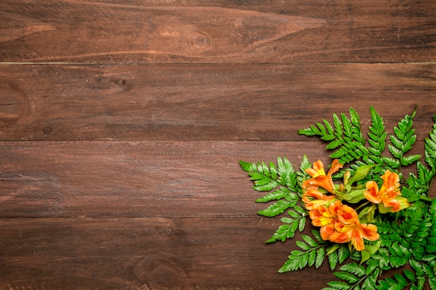 Fleurs orange à feuilles sur fond en bois