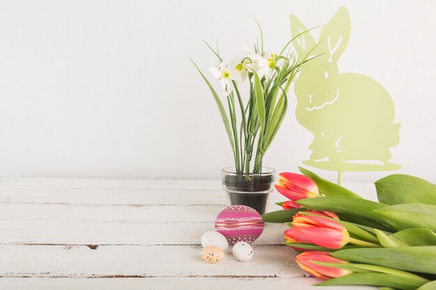 Photo gratuite fleurs près des oeufs de pâques et lapin