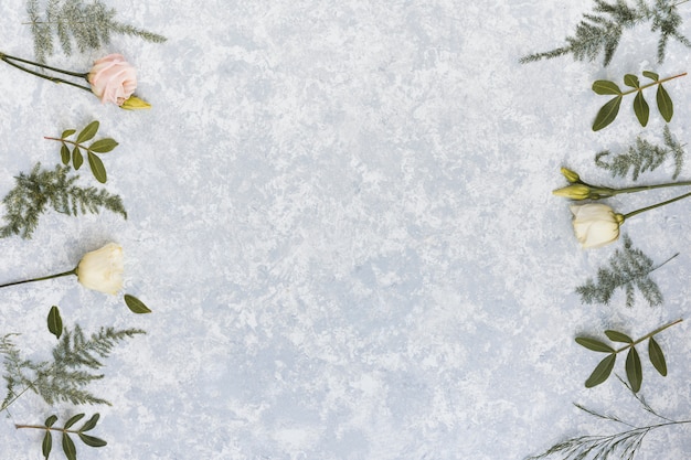 Fleurs roses avec des branches de plantes sur la table