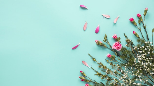 Fleurs roses avec des branches de plantes sur la table