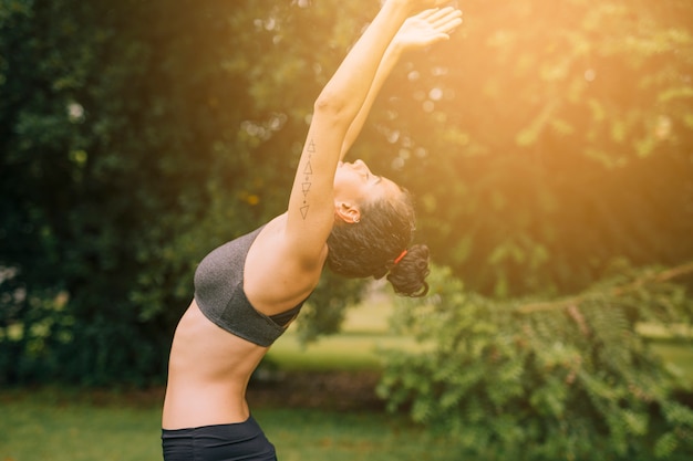 Flexible jeune femme exerçant dans le jardin