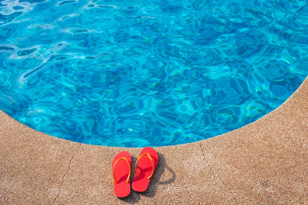 Flip flops rouge à côté de la piscine