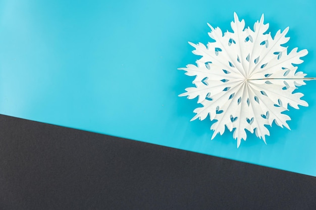 Photo gratuite flocon de neige en papier volumétrique sur fond plat coloré