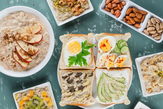 Flocons d'avoine dans des assiettes avec fruits, cannelle, sandwich, noix