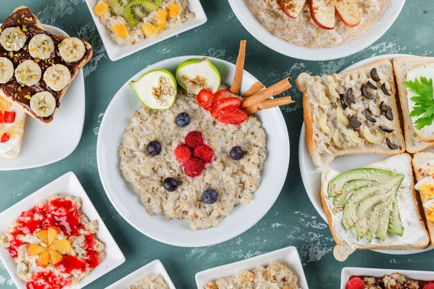 Flocons d'avoine dans des assiettes avec fruits, confiture, sandwich, cannelle