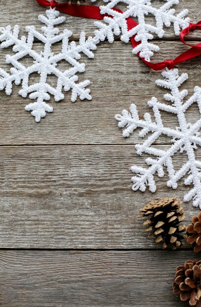 Flocons de neige, pommes de pin et ruban rouge