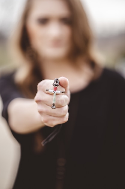 Flou d'une femme tenant un collier croix