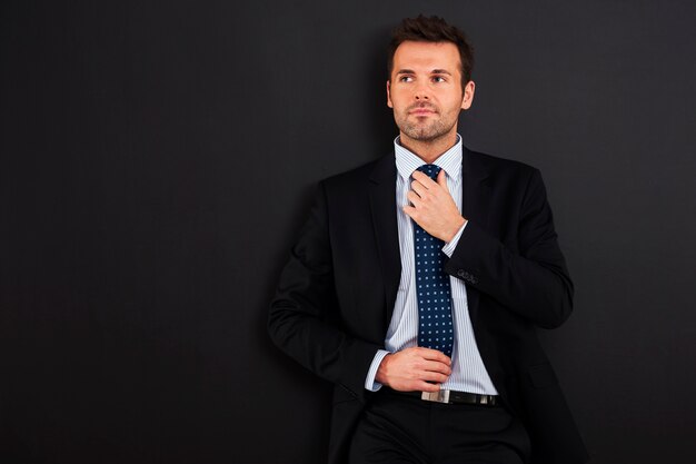 Focus homme d'affaires portant une cravate contre tableau noir