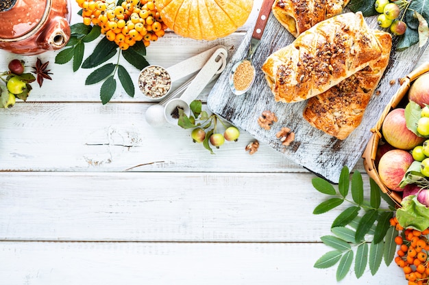 Fond d'automne. Cuisson avec de la citrouille et de la cannelle sur un fond en bois blanc. Vue de dessus, style rustique, espace copie