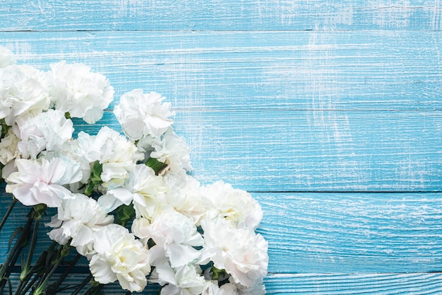 Photo gratuite fond en bois bleu avec des fleurs blanches mise à plat