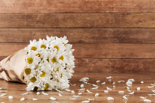 fond en bois avec bouquet de marguerite