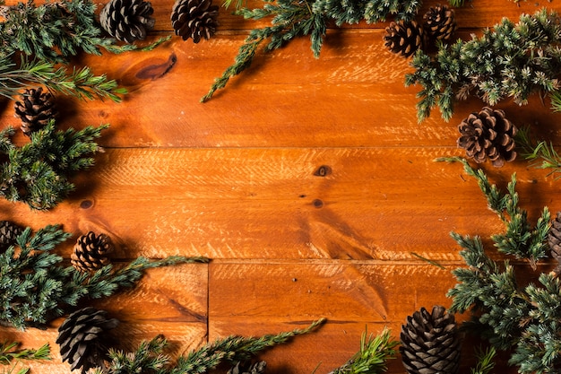 Fond en bois avec cadre de cônes de sapin de Noël