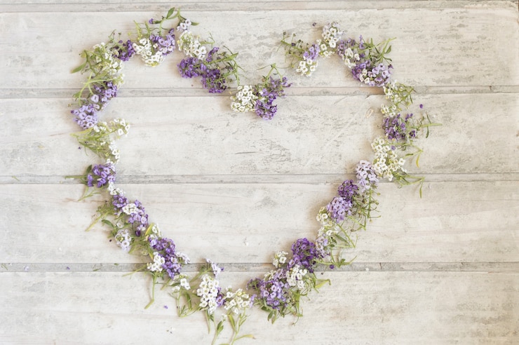 Photo gratuit fond en bois avec cadre floral en forme de cœur