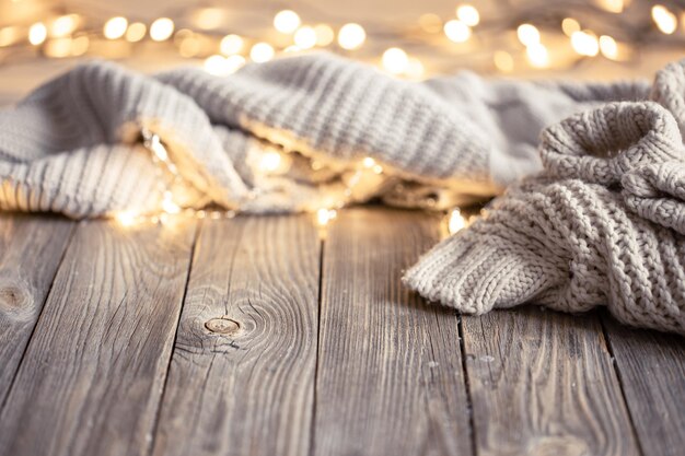 Fond confortable avec élément tricoté et lumières bokeh sur une surface en bois