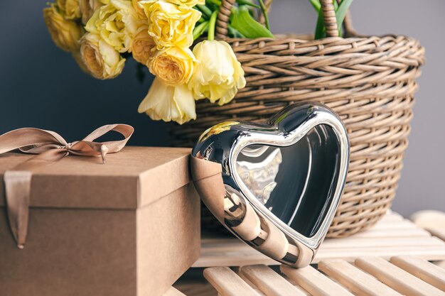 Fond de fête avec un panier de fleurs une boîte-cadeau et un coeur