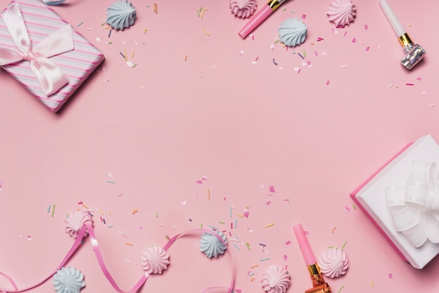 Photo gratuite fond de fête rose avec des bonbons; ventilateurs de fête et ruban frisé