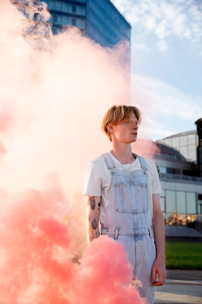 Photo gratuite fond de fumée rose avec jeune adulte