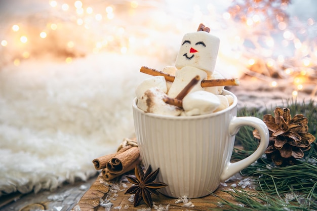 Fond de Noël avec bonhomme de neige guimauve dans une tasse