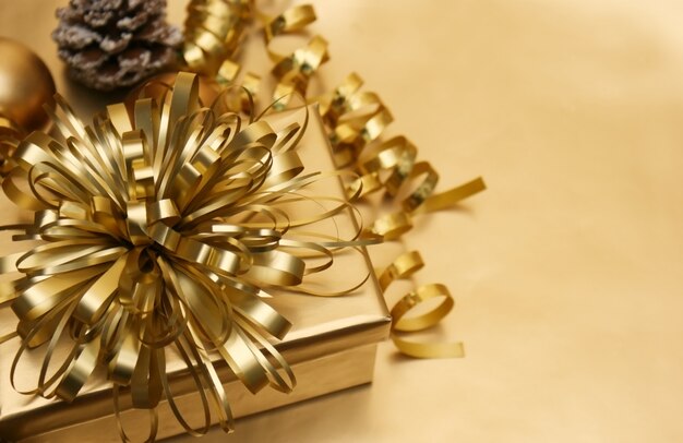 fond de Noël avec un cadeau d&#39;or et de babioles