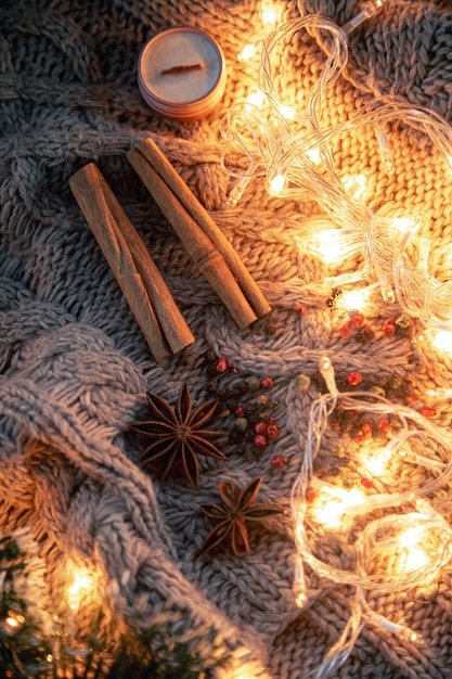 Photo gratuite fond de noël avec des guirlandes d'épices sur un fond tricoté