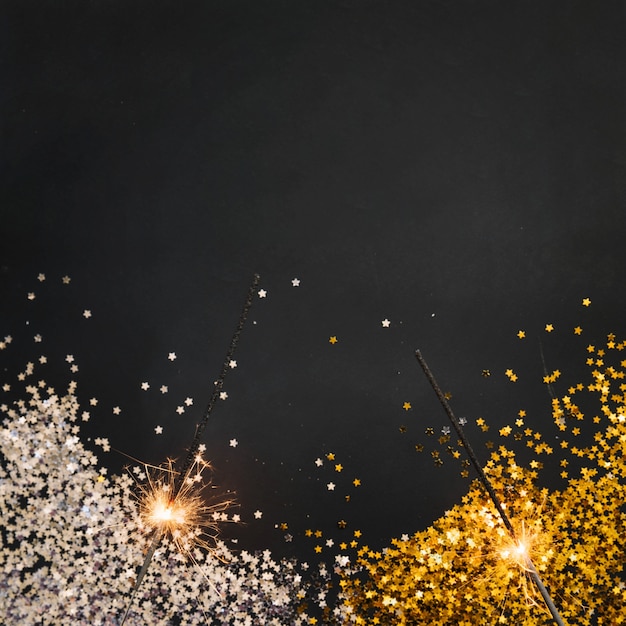 Fond de nouvel an avec des confettis et des cierges magiques
