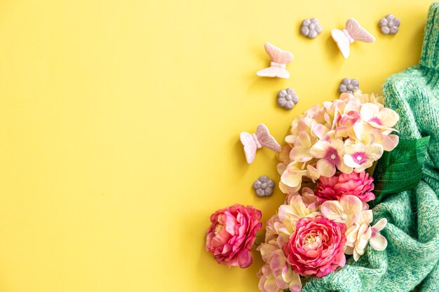 Fond de printemps avec des fleurs et des éléments tricotés à plat