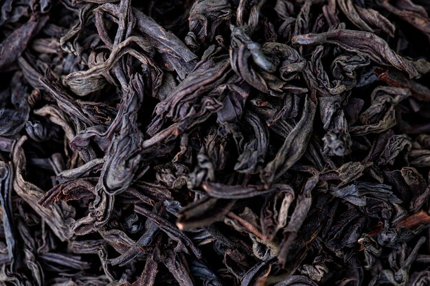 Fond de texture de feuilles de thé noir sec, vue de dessus