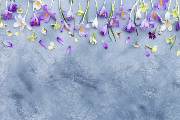 Fond vertical gris et blanc avec bordure de fleurs de printemps violet et blanc et espace pour le texte