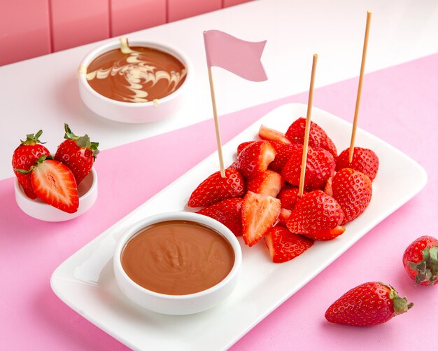 Fondue au chocolat aux fraises avec chocolat fondu et fraise sur table