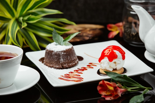 Fondue au chocolat avec crème fouettée, menthe et boule de crème glacée à la sauce rouge.