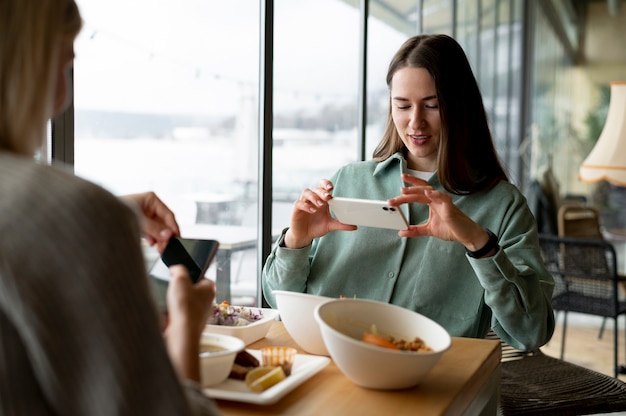 Foodie prenant une photo d'un bol avec salade et fruits de mer